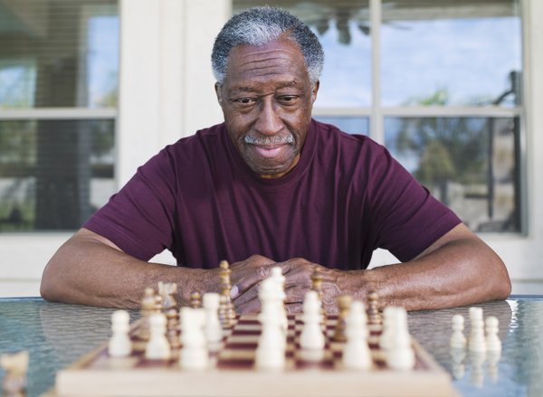 A person is staring at a chess board and thinking.