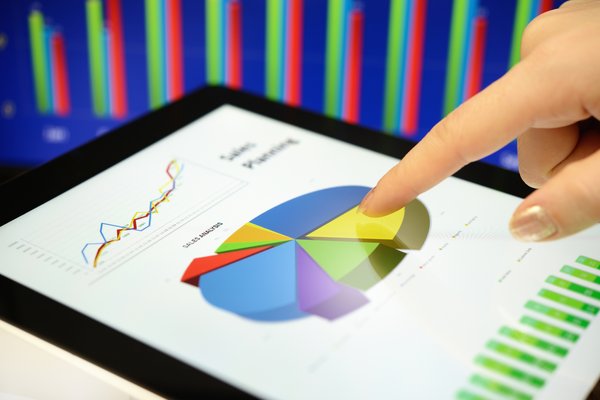 Hand pointing to a pie chart on a tablet screen.