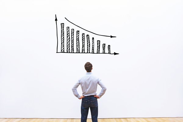 Person looking at a declining bar chart drawn on a wall.