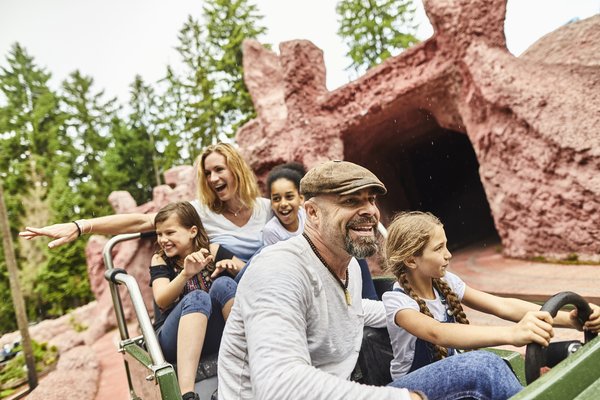 Adults and children on an amusement park ride.