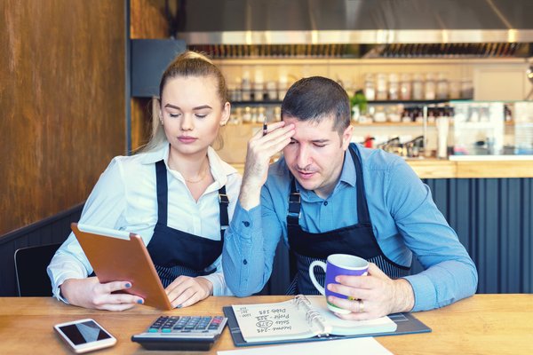 Two young entrepreneurs looking at clipboards and paperwork.