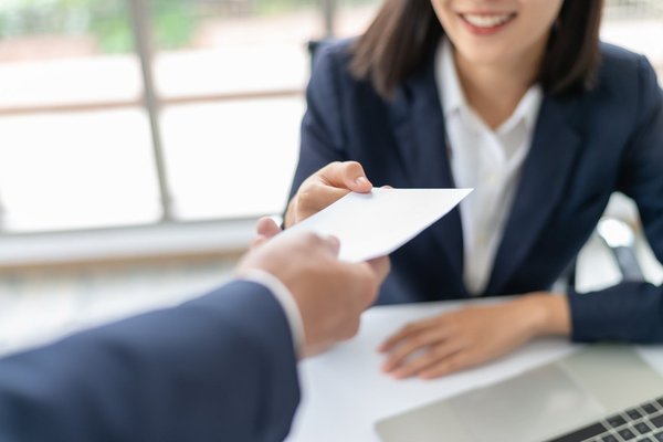 A person reaching out their hand to receive a check.